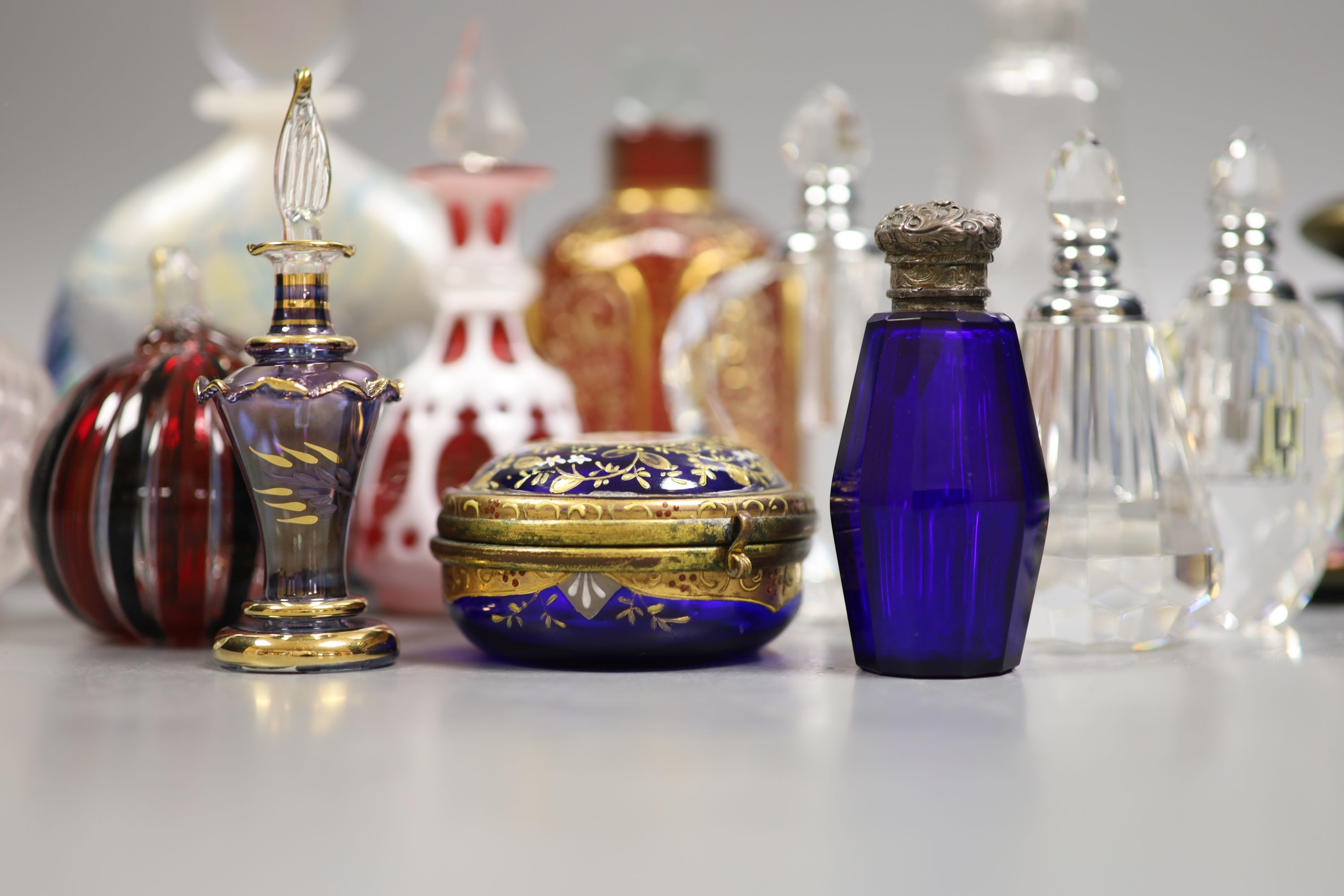 A collection of various glass scent bottles including a Lalique flower scent bottle and Bohemian examples, tallest 20.5cm